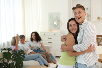 Happy friends hugging at home, selective focus