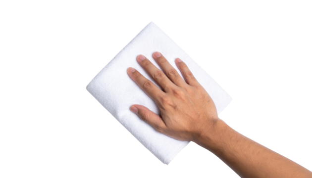 A hand is wiping a white surface with a folded white cloth against a black background.