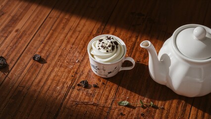 Bamboo table featuring a fresh cupcake alongside a ceramic teacup and teapot