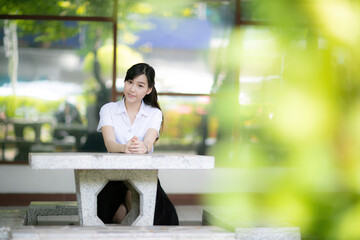 A beautiful and cute female student stood near the university’s main gate during a portrait photo shoot for the faculty’s website, bringing warmth and approachability to the digital platform.