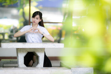 The beautiful and cute female student sat under a tree at the university garden during her faculty’s portrait photo shoot, capturing a natural and peaceful atmosphere in every frame.