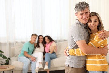 Happy friends hugging at home, selective focus