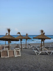 Empty Straw Parasols and Sunbeds on a Quiet Beach at Sunset