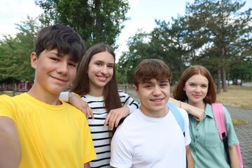 Group of teenagers taking selfie in park