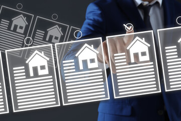 Real estate agent choosing house on virtual screen against grey background, closeup