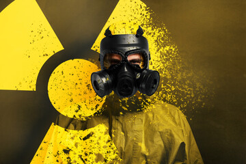 Man wearing hazmat suit and gas mask on color background. Dissolving radioactive sign
