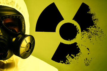 Man wearing hazmat suit and gas mask on color background. Dissolving radioactive sign behind him