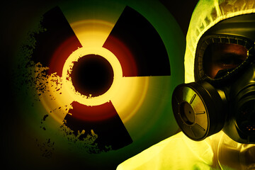 Man wearing hazmat suit and gas mask on dark background. Glowing radioactive sign behind him
