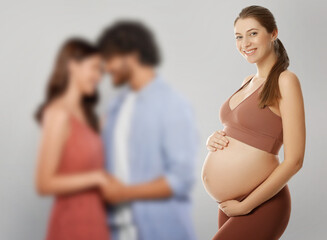 Surrogate mother and intended parents against light grey background, selective focus