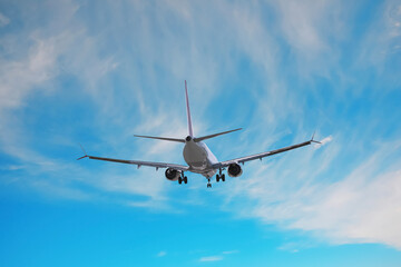 Airplane flying in beautiful blue sky with clouds
