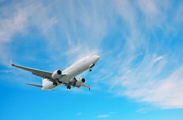 Airplane flying in beautiful blue sky with clouds