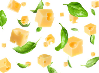 Cheese cubes and green basil leaves falling against white background