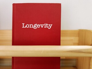 Red book with title written - Longevity - means long-lived members population, living a longer and healthier life - Healthy habits may slow aging