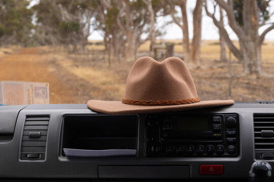 felt hat on dashboard of vehicle parked on rural road