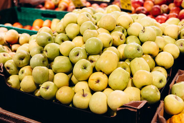 Pile of farm apples in supermarket display, imperfect natural fruits.