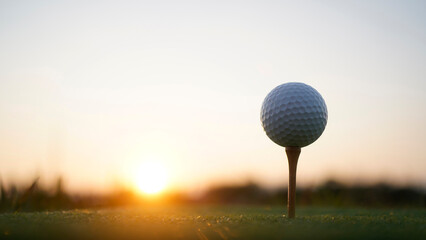 Golf clubs and golf balls on a green lawn in a beautiful golf course with morning sunshine.