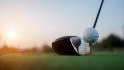 Golf clubs and balls on a green lawn in a beautiful golf course with morning sunshine.