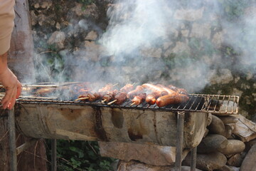 Smoke rises from a sizzling barbecue grill