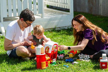 allied health professional speech therapist working with young child playing together with toys out