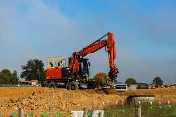 Excavator earthmoving equipment working on dirt pile at construction site