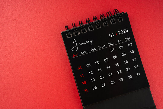 January black desk calendar for 2026 year on red cover background with copy space.