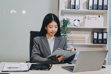 Portrait of Young Asian woman hand freelancer is working her job on computer tablet in modern...