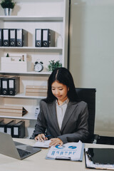Portrait of Young Asian woman hand freelancer is working her job on computer tablet in modern...