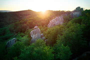Aerial view of climber standing atop rock formation at Dovbush Rocks in Carpathian mountains,...