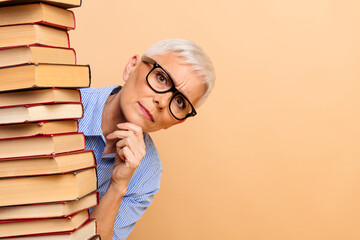 Mature businesswoman with short white hair wearing glasses and blue striped shirt posing beside a...