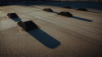 Shadows cast by parking barriers on pavement from a perspective angle