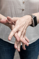 Woman applying hand cream while wearing smartwatch: moisturizing skincare routine