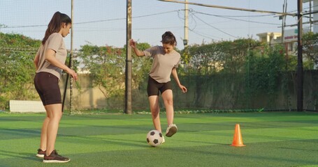 Indian asian happy young adult gen z girl group of sports woman playing football outdoor yard smiling female lady players game kicking soccer ball team have fun joy give high five outside ground place - Powered by Adobe