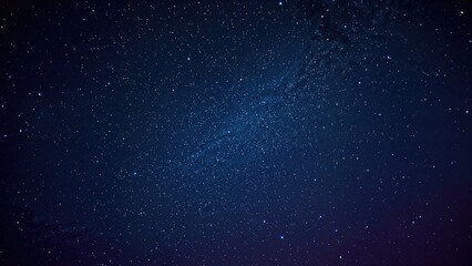 Fototapeta premium Glowing stars scattered across a deep blue and lilac sky