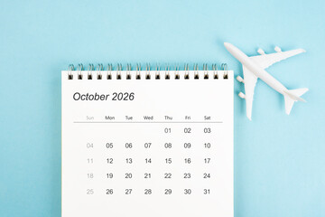 October 2026 calendar and airplane toy on blue color background, Travel plan concepts.