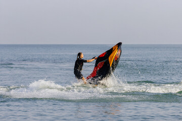 Young man rides a jet ski across turquoise waters during seaside vacation. Concept water sports...