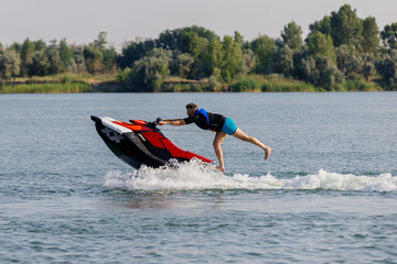 A young guy enjoying a fast ride on a jet ski under the summer sun. Concept thrill, freedom, and...