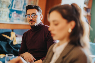 A man and woman share a discussion in a modern workspace, fostering collaboration and creativity....