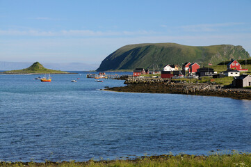 A lone fishing boat sails on the open Norwegian Sea under a vast sky, surrounded by distant...