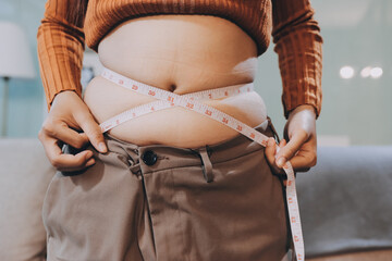 woman's hand holding excessive belly fat, overweight concept