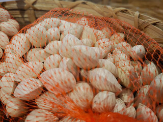 Pile of Pistachio nuts in white shells in red mesh bags