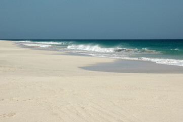 Waves crash gently on a deserted white sand beach in Boavista, Cape Verde, with the turquoise...