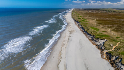 A breathtaking aerial view of Denmarks coastline, showcasing a long sandy beach meeting the azure...