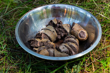 Still life with Blood sausage Izig-khan at steel bowl on green grass. National Tuvan and Buryat...