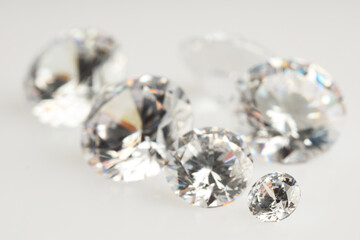 Many shiny diamonds on light background, closeup