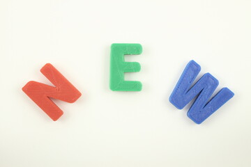 色の違うNEWの文字、白背景に並ぶ