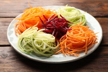 Different vegetable noodles on wooden table, closeup