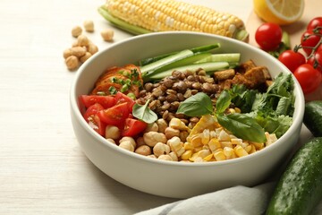 Healthy vegetarian food. Delicious Buddha bowl and ingredients on light wooden table, closeup. Space for text