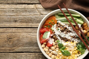 Healthy vegetarian food. Delicious Buddha bowl served on wooden table, top view. Space for text