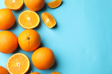 Fresh ripe oranges on light blue background, flat lay. Space for text