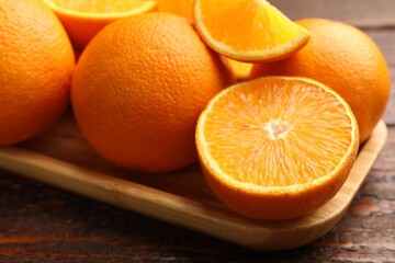 Fresh ripe oranges on wooden table, closeup
